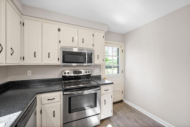 kitchen featuring white cabinets, stainless steel appliances, and dark countertops