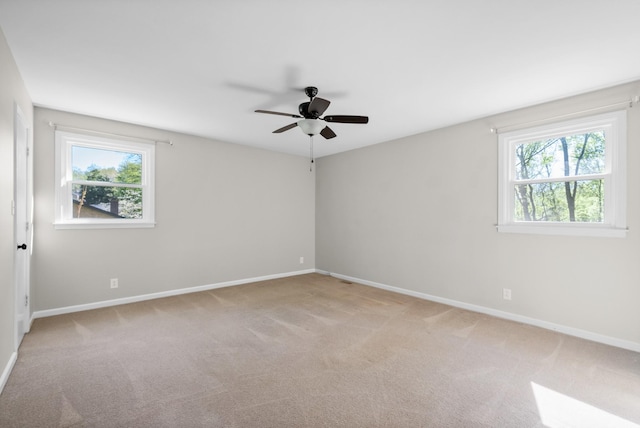 unfurnished room featuring ceiling fan, baseboards, and light colored carpet