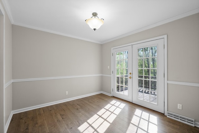 interior space featuring wood finished floors, visible vents, ornamental molding, french doors, and baseboards