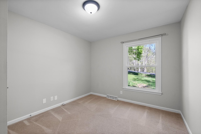 empty room featuring baseboards, visible vents, and carpet