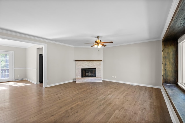 unfurnished living room featuring ceiling fan, baseboards, crown molding, and wood finished floors