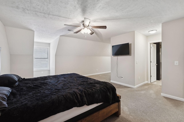 carpeted bedroom with a textured ceiling, a ceiling fan, baseboards, and visible vents