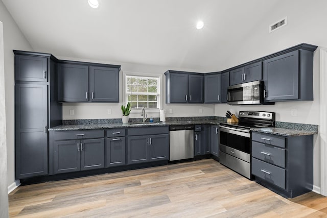 kitchen with visible vents, stainless steel appliances, lofted ceiling, and a sink