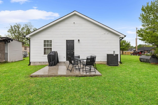 rear view of property with a yard, central air condition unit, and a patio