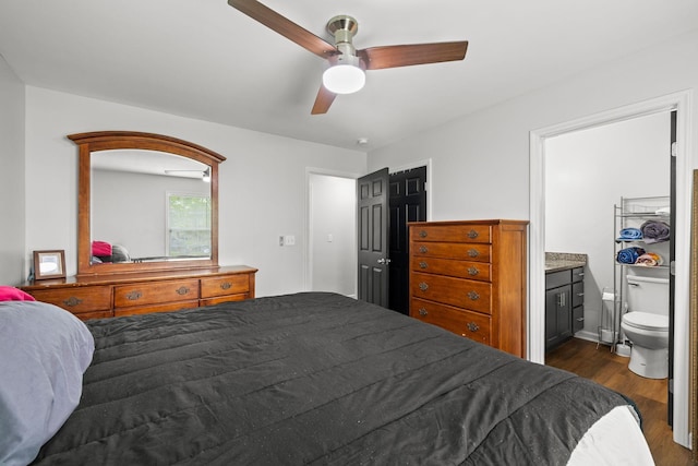 bedroom featuring dark wood-type flooring, connected bathroom, and a ceiling fan