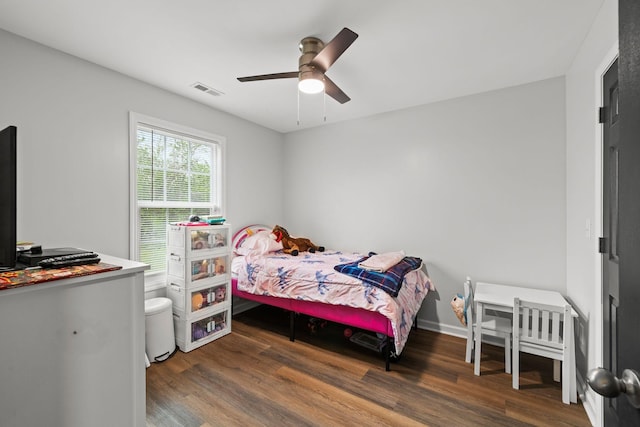bedroom with a ceiling fan, visible vents, and wood finished floors