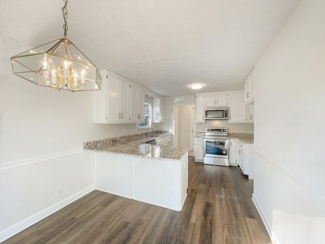 kitchen with light stone counters, a sink, stainless steel appliances, dark wood finished floors, and a peninsula