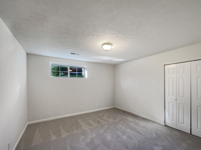 unfurnished bedroom with baseboards, visible vents, carpet floors, and a closet