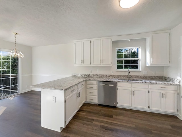 kitchen featuring a peninsula, stainless steel dishwasher, a sink, and a textured ceiling