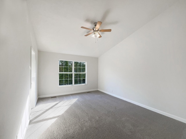 carpeted spare room with baseboards, a ceiling fan, and vaulted ceiling