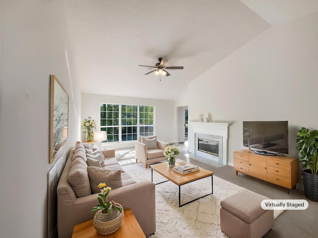 living area with high vaulted ceiling, a high end fireplace, and ceiling fan