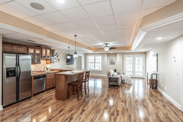 kitchen featuring a sink, a breakfast bar area, stainless steel appliances, and dark wood-style floors