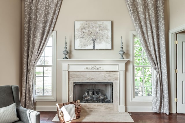 living area featuring a high end fireplace and baseboards
