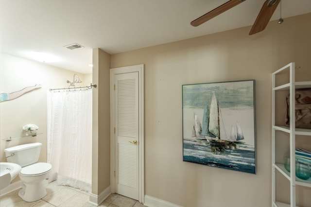 bathroom with a shower with curtain, toilet, a ceiling fan, tile patterned flooring, and a closet
