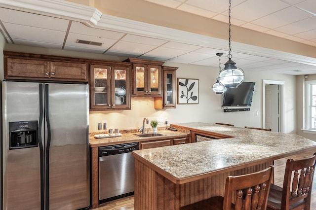 kitchen with a kitchen breakfast bar, a sink, visible vents, light countertops, and appliances with stainless steel finishes