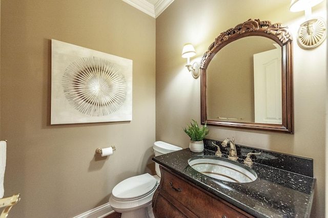 bathroom featuring baseboards, crown molding, vanity, and toilet