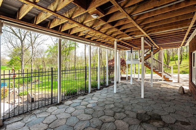 view of patio / terrace featuring fence and stairs