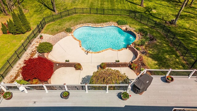 view of pool featuring fence, a yard, and a deck