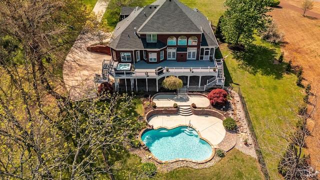 back of house featuring stairs, an outdoor pool, a balcony, a wooden deck, and a patio