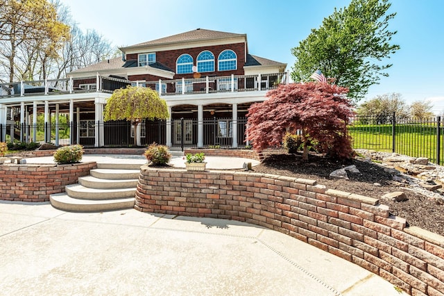back of house featuring a balcony and fence private yard