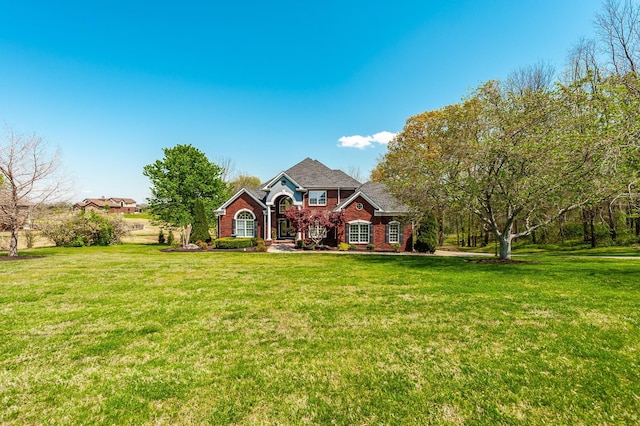 view of front of house featuring brick siding and a front yard