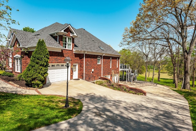 view of front of property featuring stairway, a front lawn, roof with shingles, concrete driveway, and brick siding