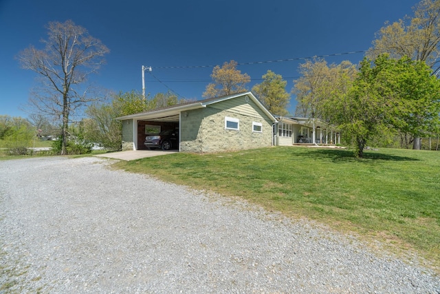 view of home's exterior featuring a lawn, concrete block siding, a carport, a porch, and gravel driveway