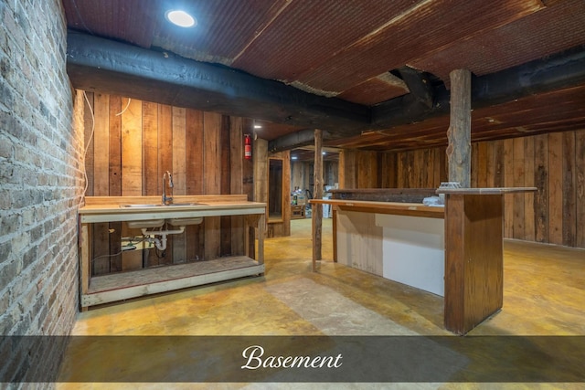 bar with concrete flooring, wood walls, and a sink