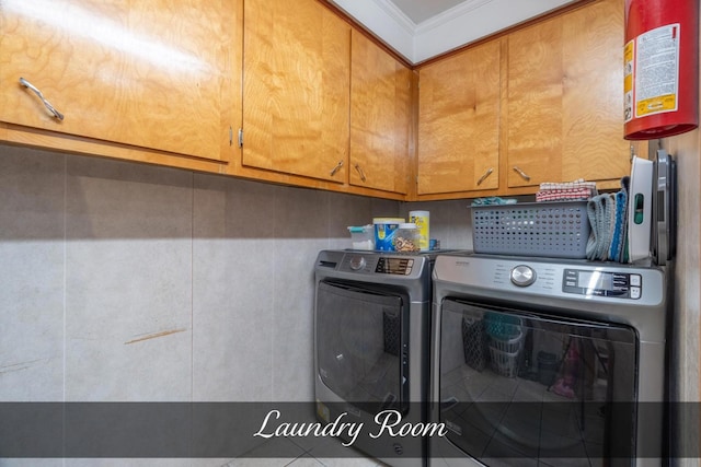 washroom featuring separate washer and dryer, ornamental molding, and cabinet space