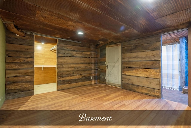 spare room with wood ceiling, wooden walls, and wood finished floors