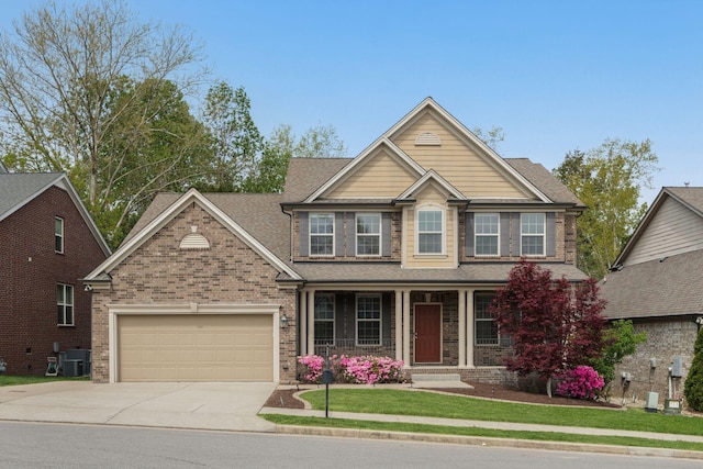 craftsman-style house featuring concrete driveway, a front lawn, covered porch, a garage, and brick siding