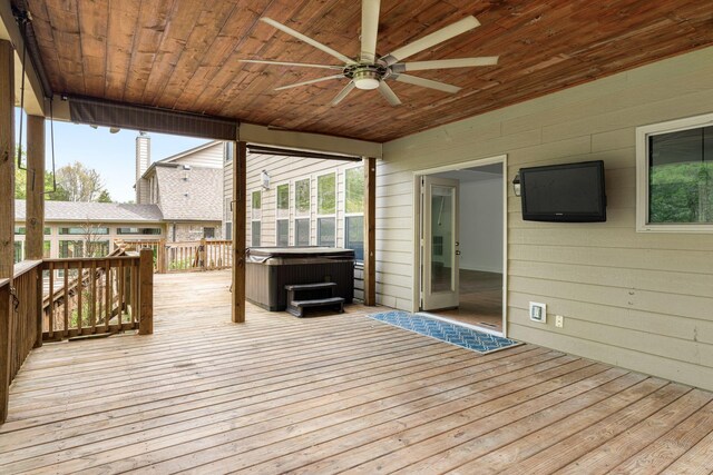 wooden deck with a hot tub and ceiling fan