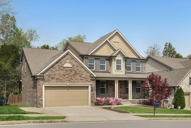 craftsman inspired home with cooling unit, driveway, a porch, brick siding, and a garage
