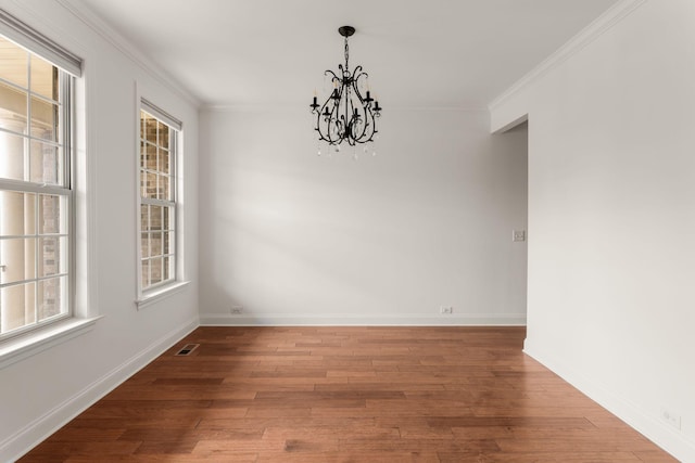 unfurnished dining area featuring an inviting chandelier, wood finished floors, visible vents, ornamental molding, and baseboards