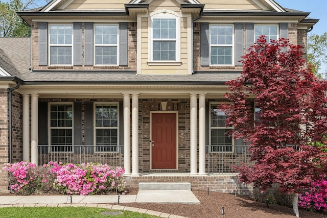 view of front of property with a porch and brick siding