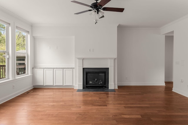 unfurnished living room featuring ceiling fan, ornamental molding, and light wood-type flooring