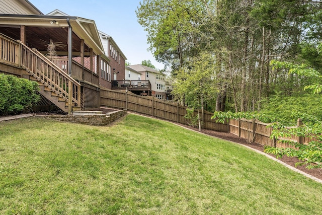 view of yard with a fenced backyard and stairs