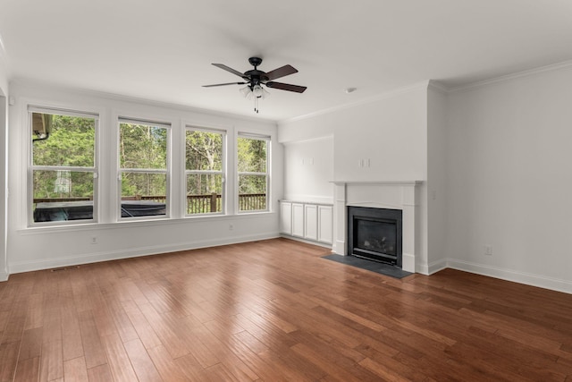 unfurnished living room with visible vents, baseboards, ceiling fan, ornamental molding, and wood-type flooring
