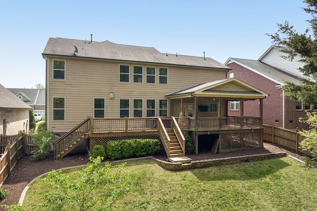 rear view of property featuring a fenced backyard, a wooden deck, and stairs