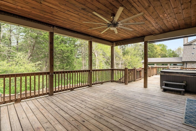 wooden terrace with a ceiling fan and a hot tub