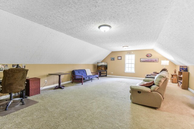carpeted office featuring vaulted ceiling, a textured ceiling, and baseboards