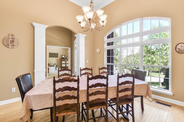 dining room with baseboards, arched walkways, visible vents, and a wealth of natural light