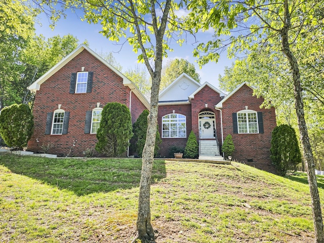 view of front facade with a front lawn and brick siding
