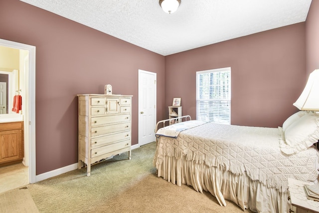 bedroom with baseboards, a textured ceiling, light colored carpet, and connected bathroom