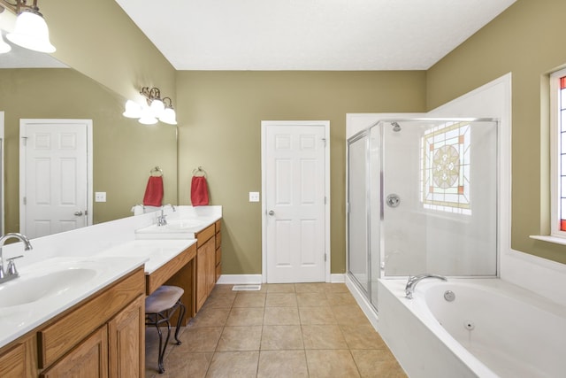 bathroom featuring a shower stall, double vanity, tile patterned floors, and a sink