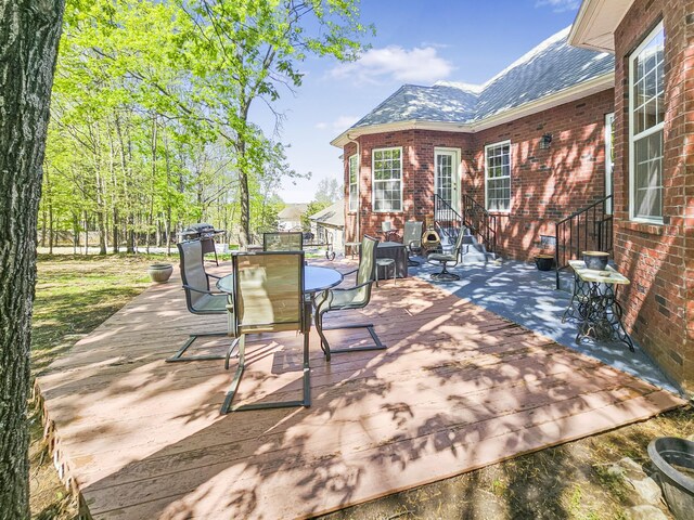 view of patio with outdoor dining space, entry steps, and a deck