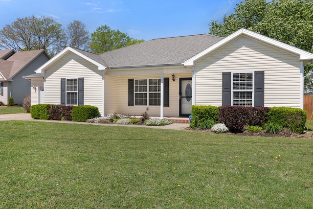 ranch-style house featuring a porch, a shingled roof, and a front lawn