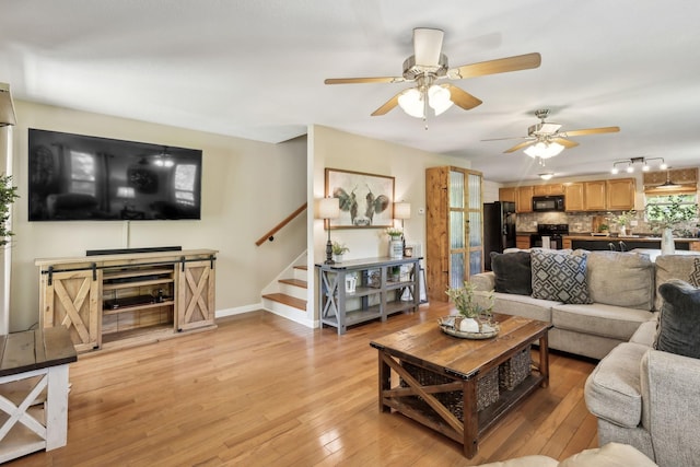 7565 N County Line Rd, Fairview, TN 37062 - living area featuring stairway, rail lighting, a ceiling fan, and light wood-type flooring