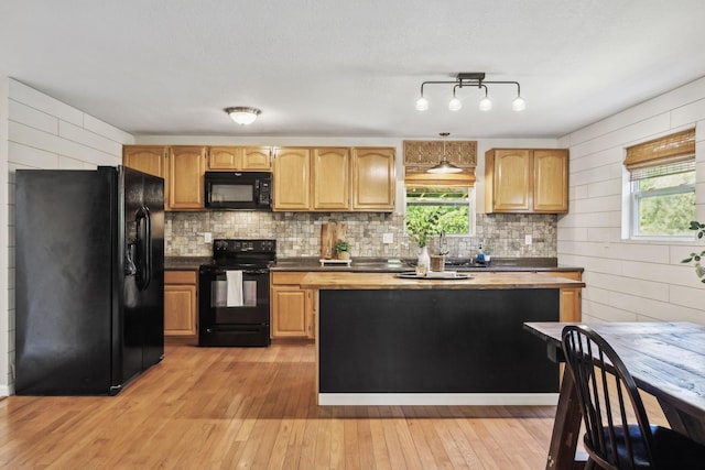 7565 N County Line Rd, Fairview, TN 37062 - kitchen featuring light wood-style flooring, backsplash, black appliances, and a healthy amount of sunlight