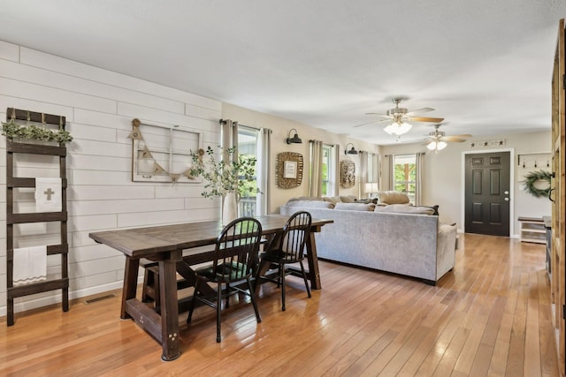 7565 N County Line Rd, Fairview, TN 37062 - dining area with wooden walls, light wood-style floors, a ceiling fan, baseboards, and visible vents